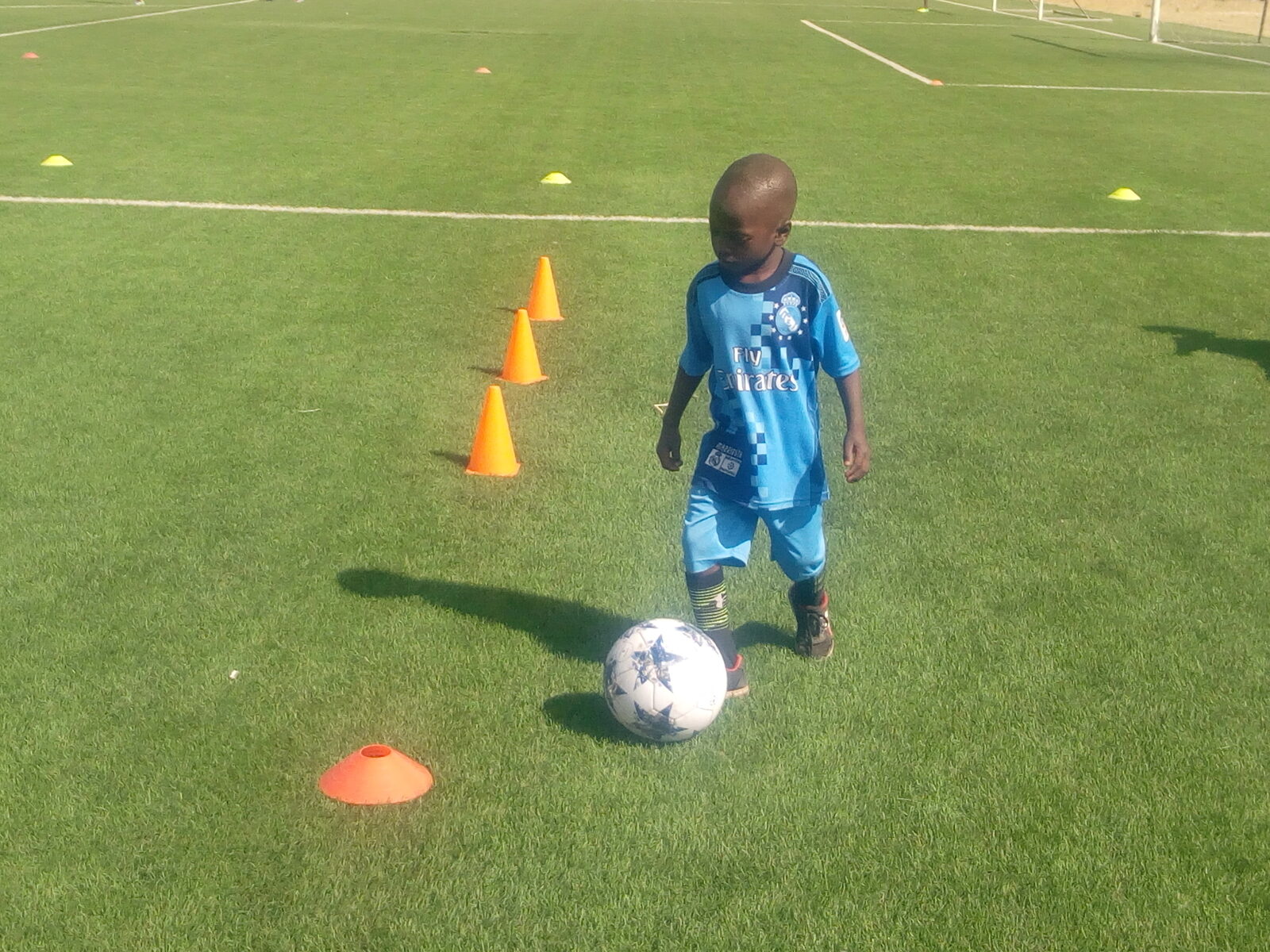 Jeune joueur travaillant son dribble entre des plots